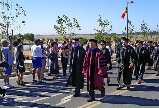 Professor Winston walking with other professors down a street during the opening day procession in 2005