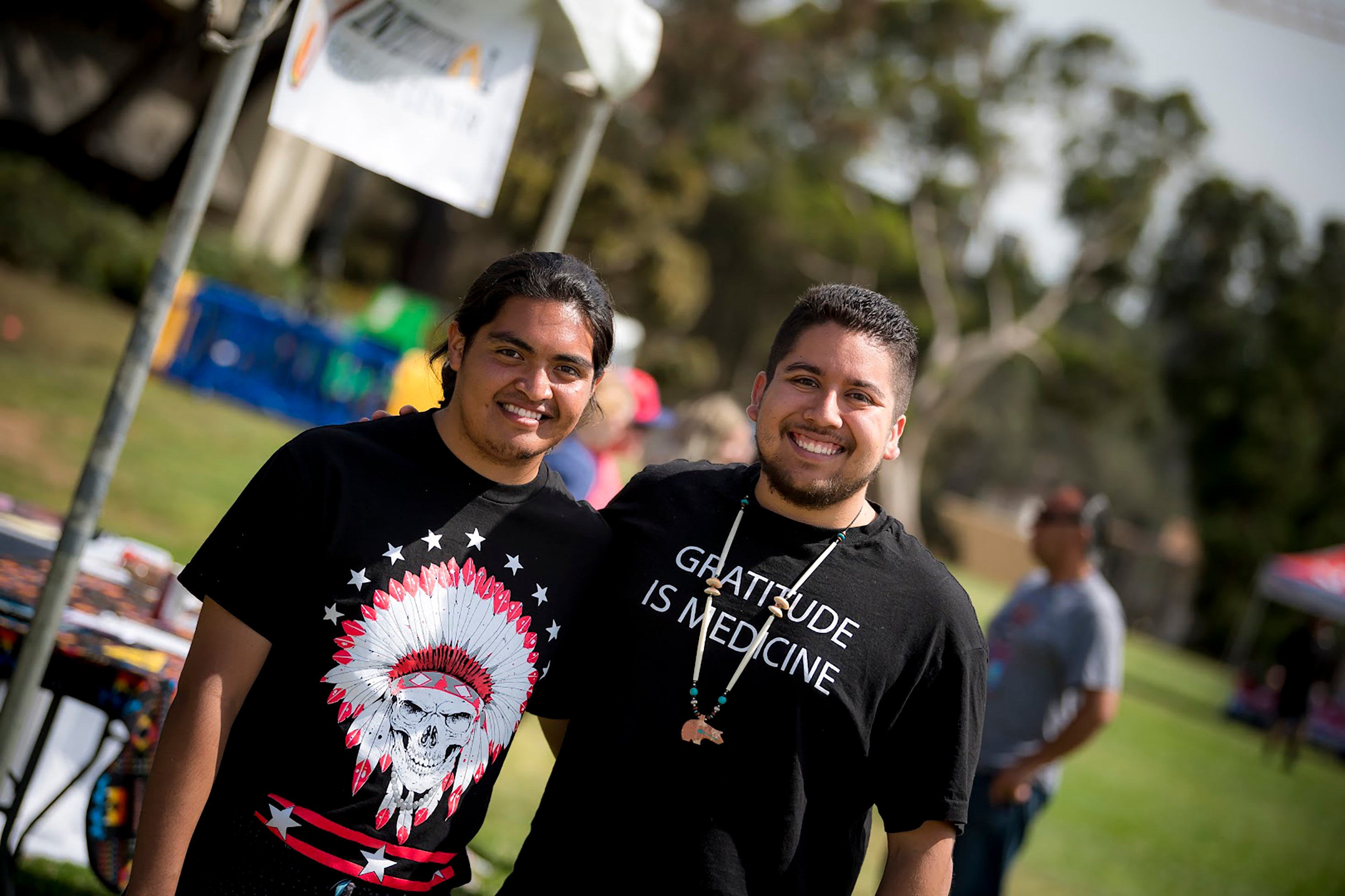 Two young Native American men standing together on campus