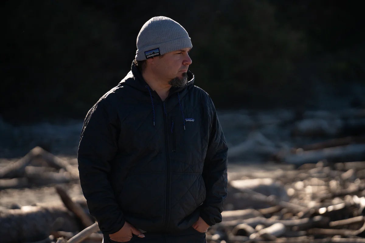 A picture of a man outdoors in a jacket and beanie hat