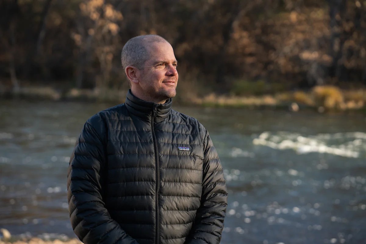 A man standing in front of a river