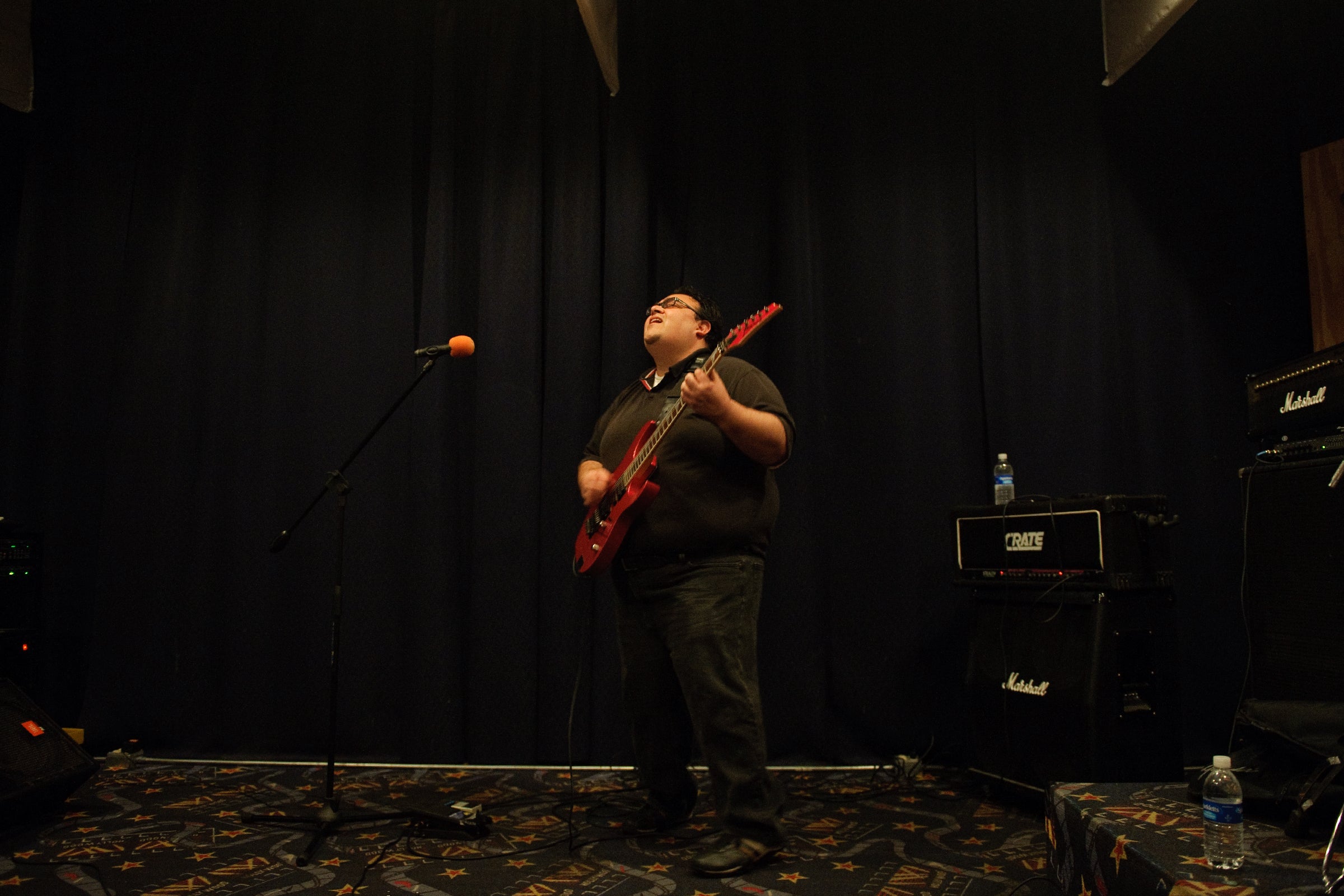 Marco Angulo plays guitar with a soulful expression on his face