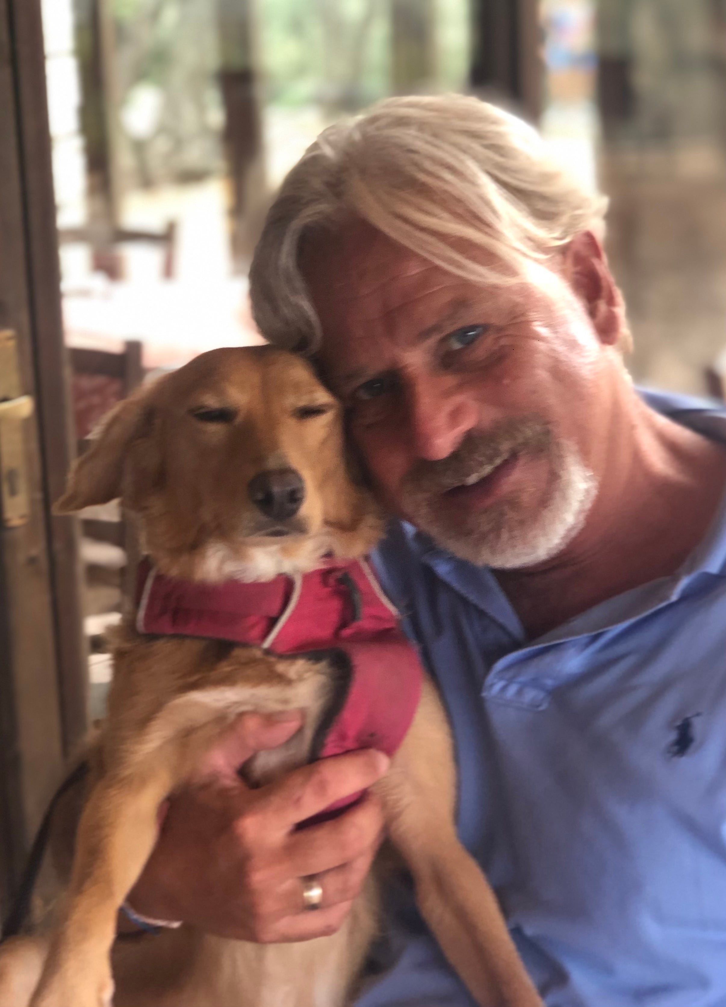 A man holds a young dog