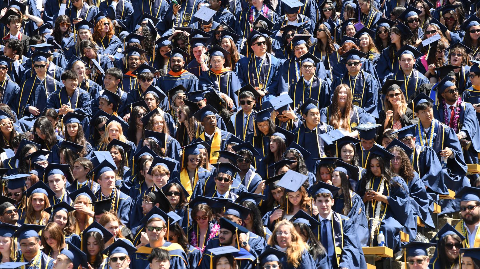 A sea of college students in caps and gowns at graduation