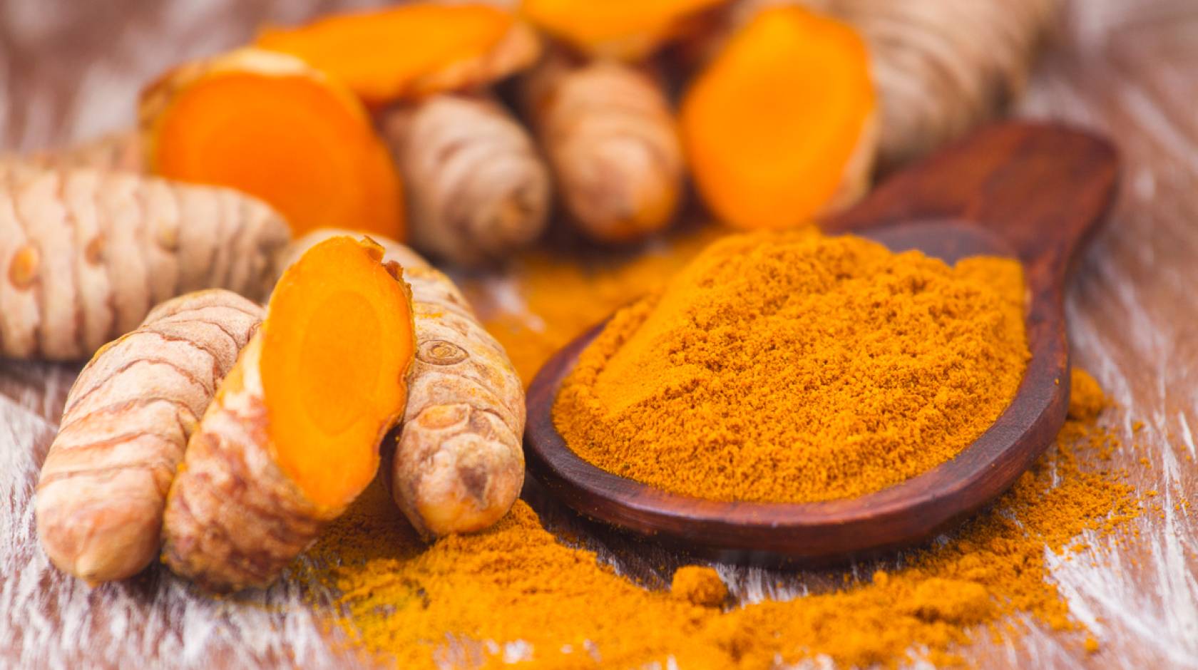 Turmeric root next to turmeric powder