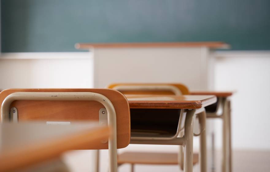 Classroom chairs and desks facing chalkboard