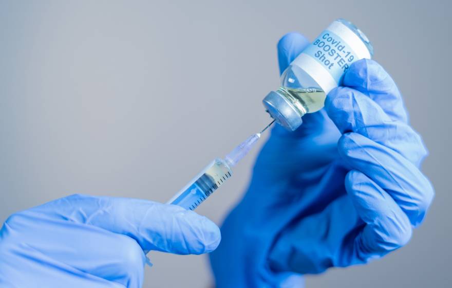 Close up of doctor or nurse's hands preparing to administer a COVID-19 booster shot